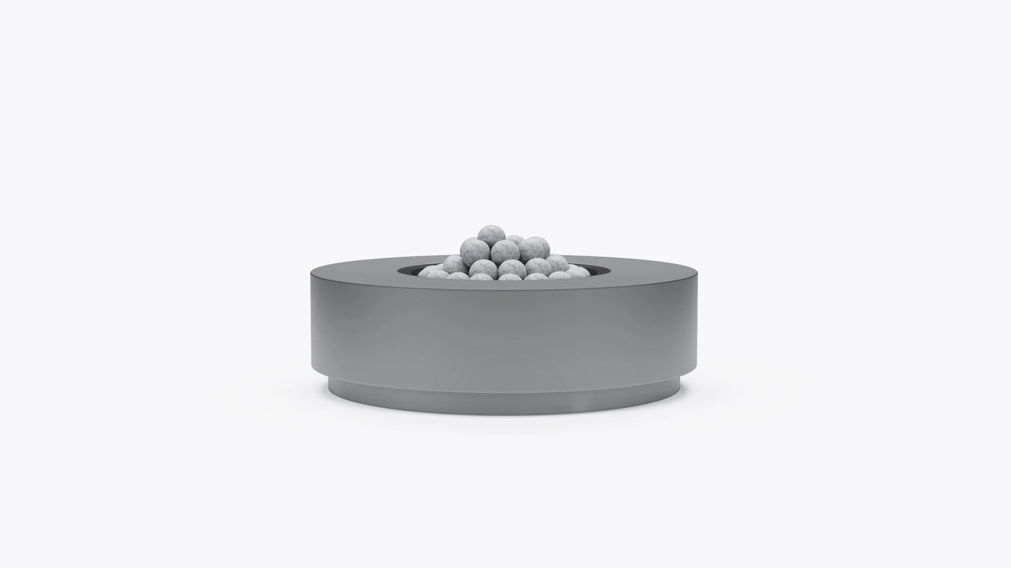 Round concrete outdoor fire pit table with recessed burner and fire stones